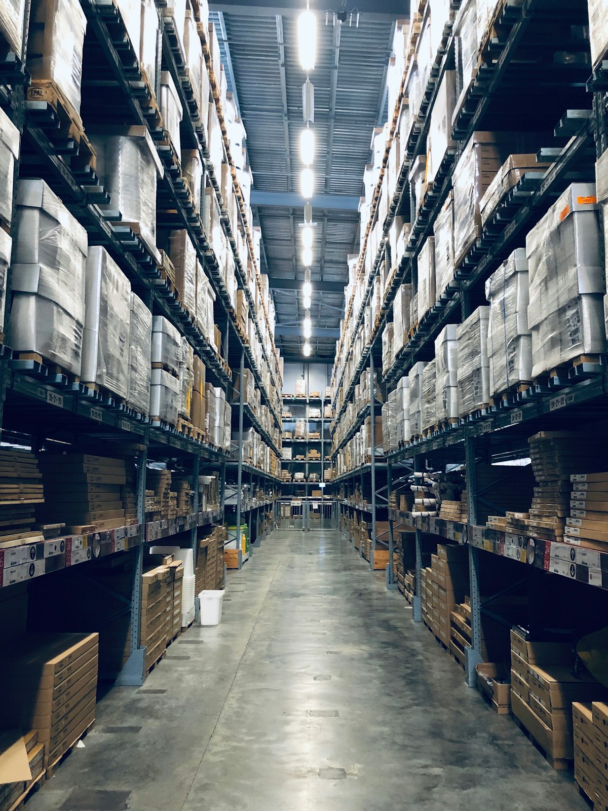 a forklift driving through a warehouse filled with pallets
